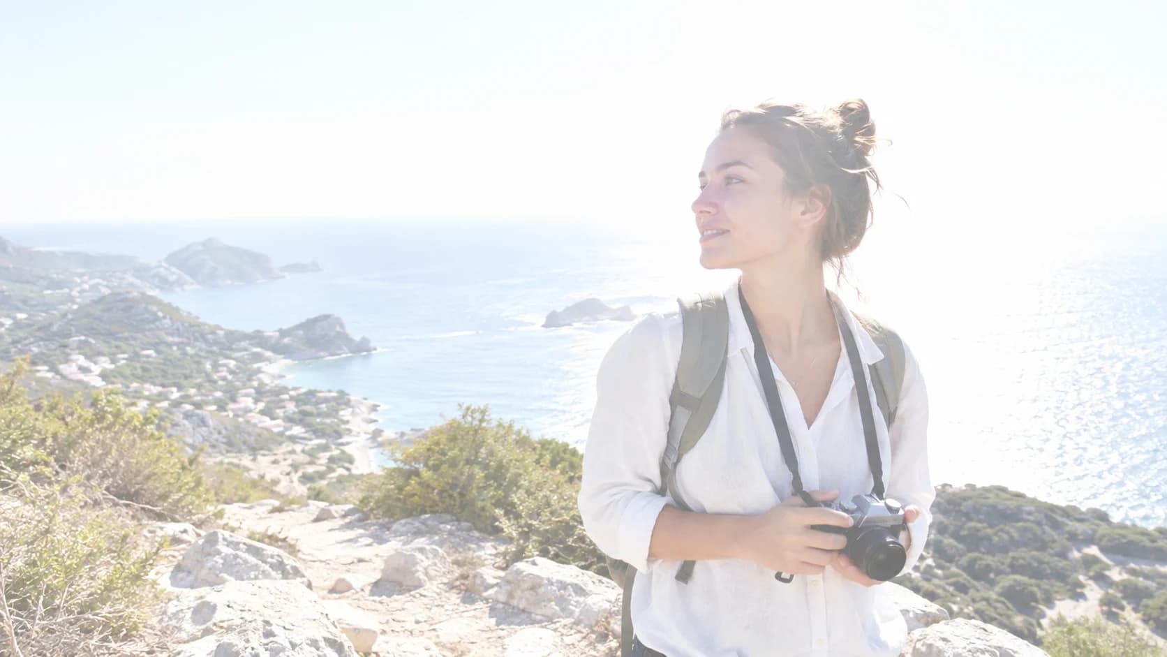 Overexposed traveler at a coastal viewpoint before correction