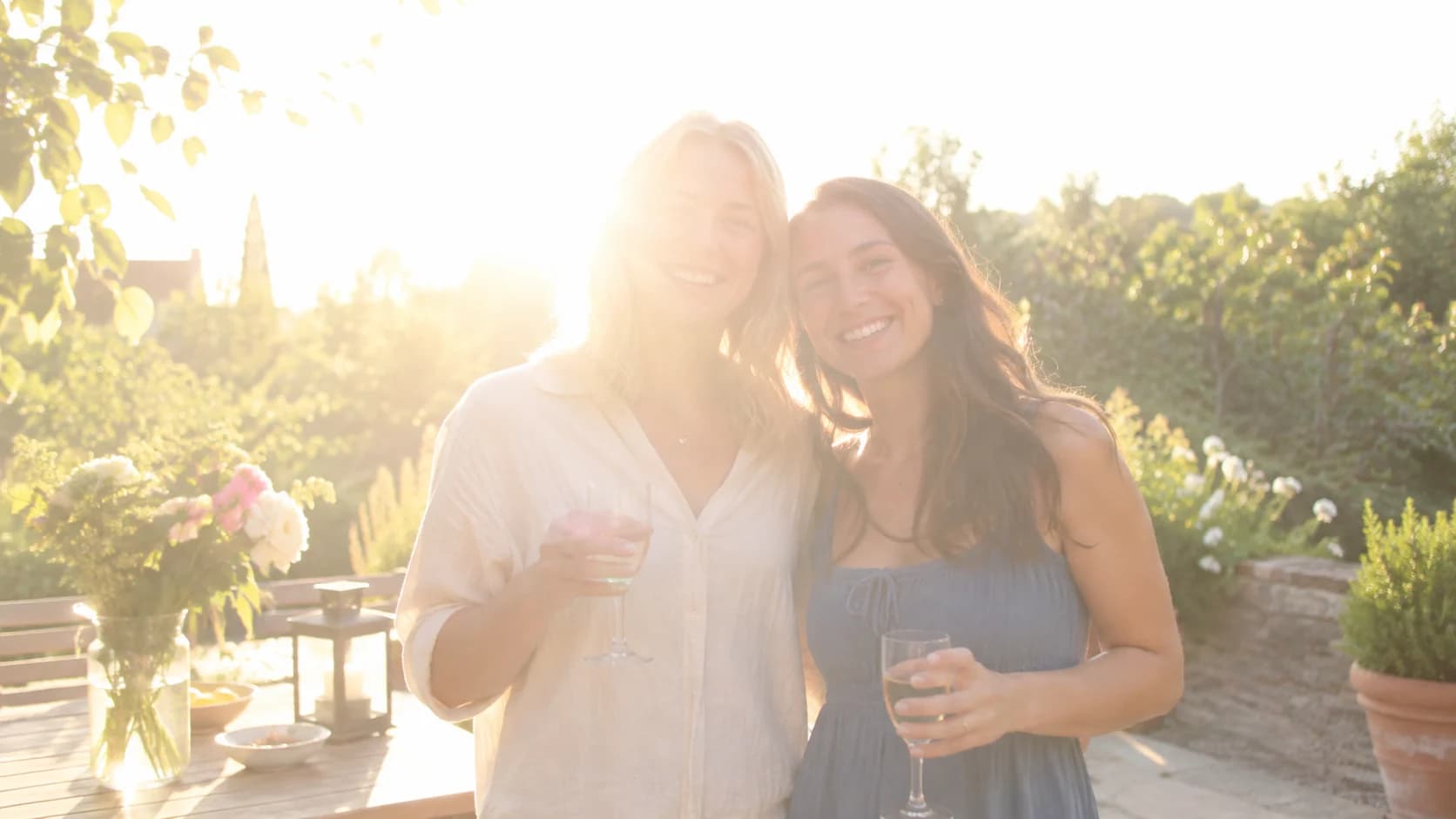 Two friends at a bright garden celebration before correction