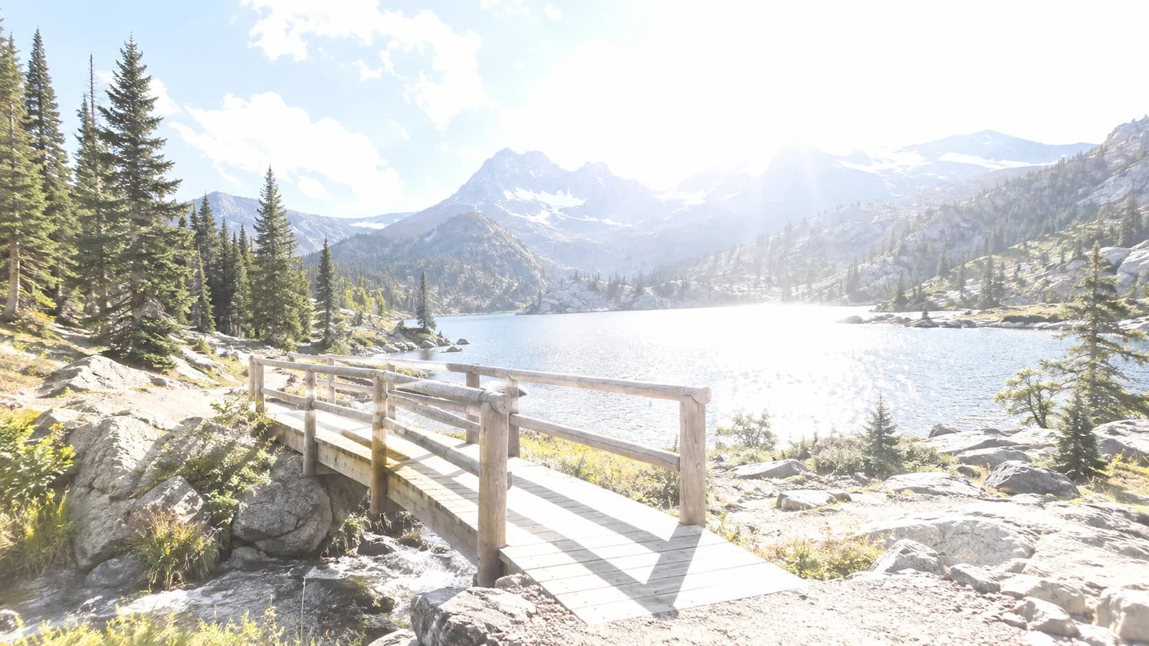 Overexposed mountain lake footbridge before correction